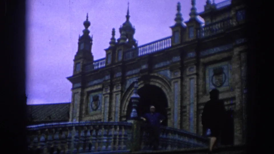 A wider 1966 Spain frame shows Plaza de España bridge railings, towers, arch details, and a passing visitor.