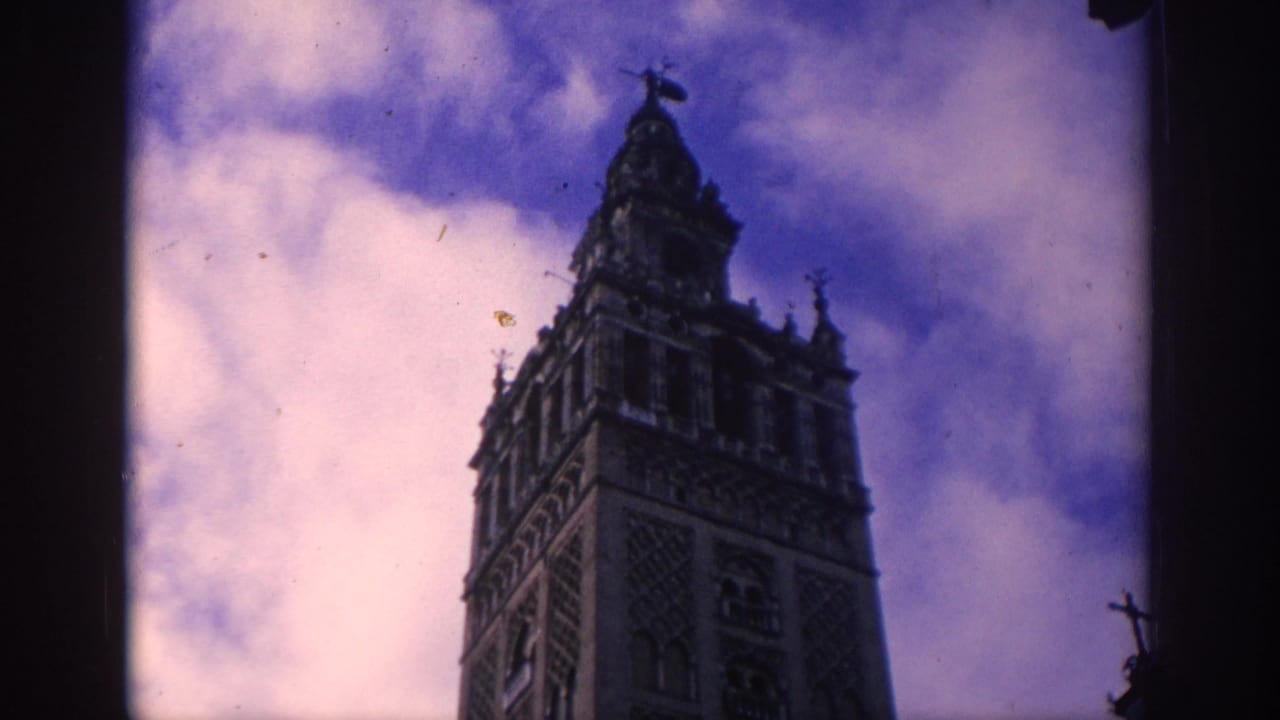 Tall historic tower seen from below against a purple-blue cloudy sky.