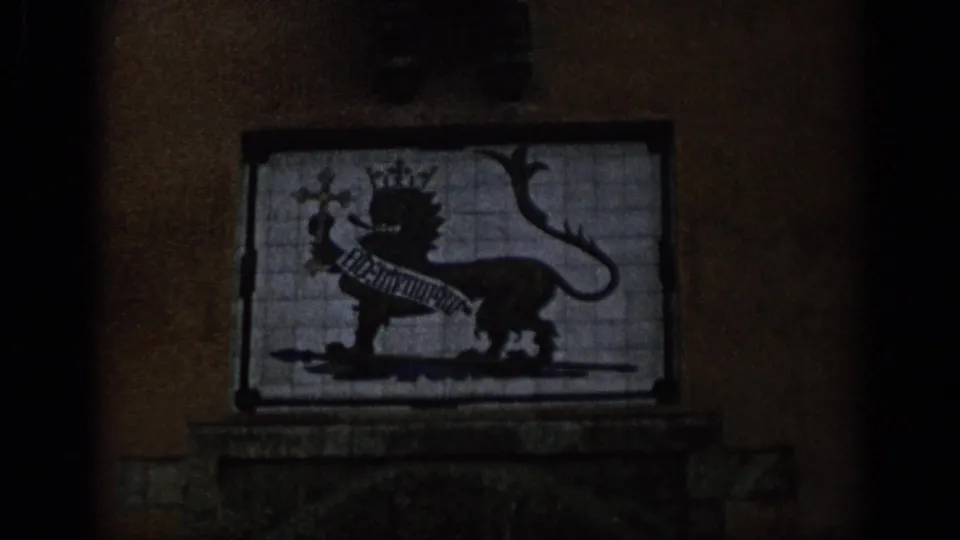 1966 Spain 8mm frame showing a tiled heraldic panel with a crowned lion figure on an exterior wall.