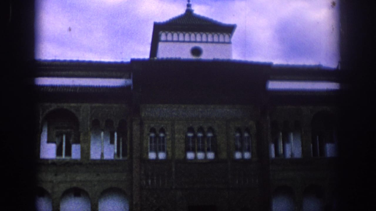 Closer view of the tower and upper facade with rows of arched windows.