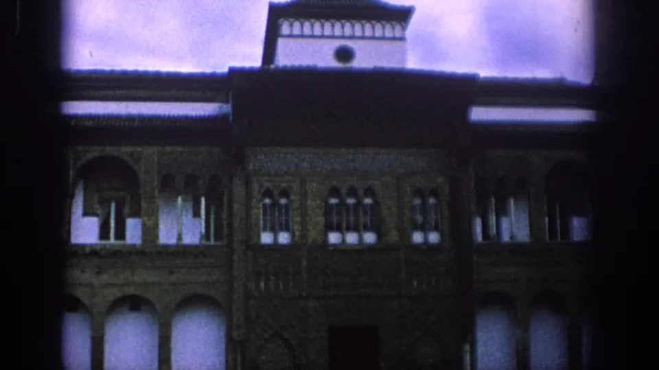 1966 Spain 8mm view of a historic facade with arched lower openings, patterned wall surfaces, upper windows, and a central tower.