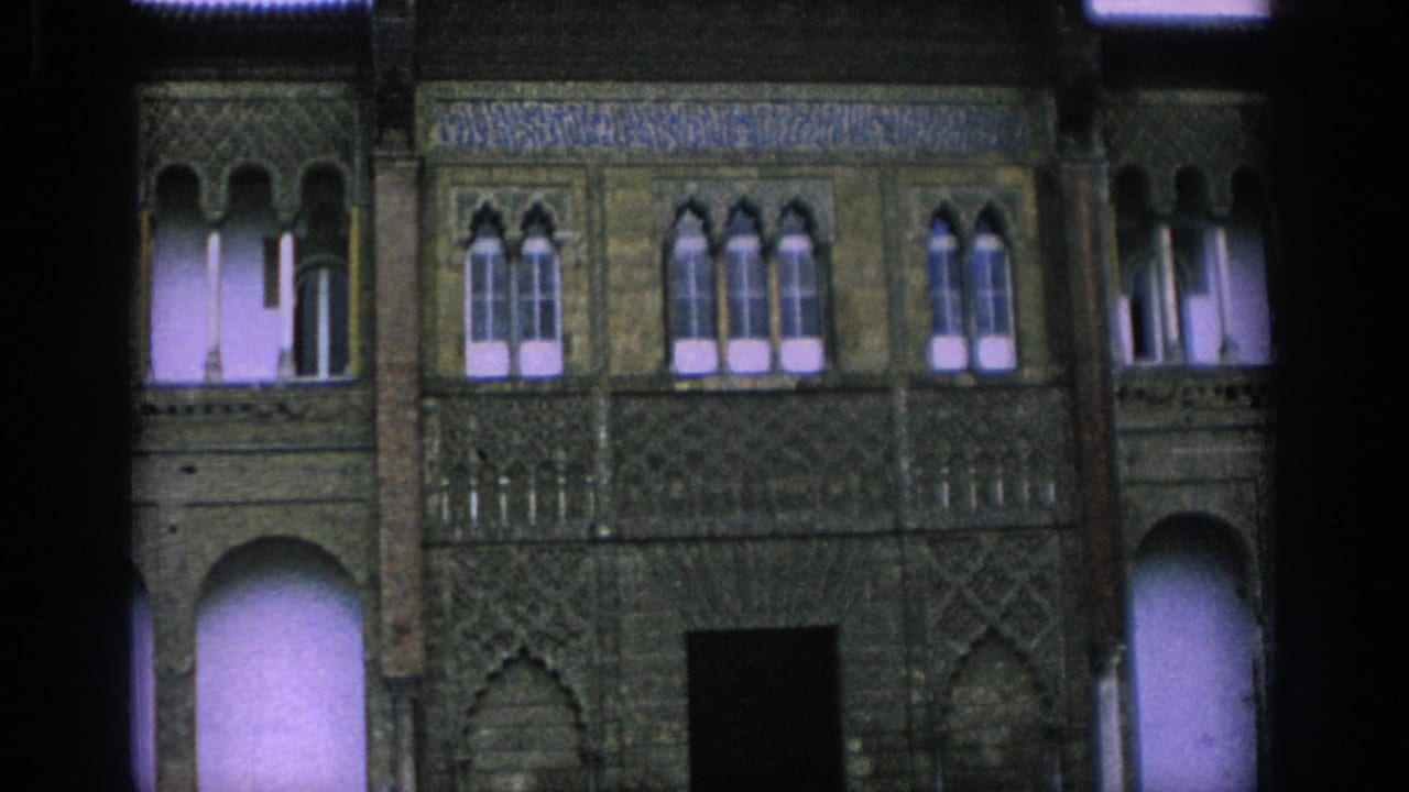 Historic facade with arched windows, carved stonework, and a dark central doorway.