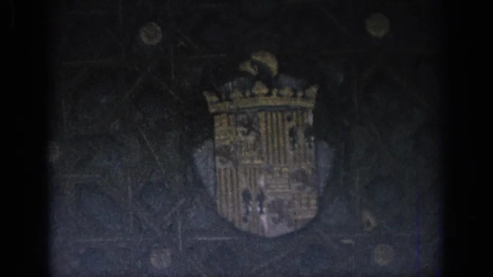 Closer 1966 Spain frame showing a crowned shield with gold and blue tones on a dark decorated wall.