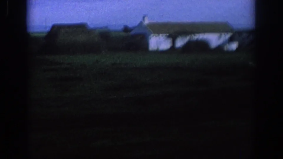 1966 Spain travel frame with a white rural house, dark roof, open ground, and blue sky seen in soft focus.