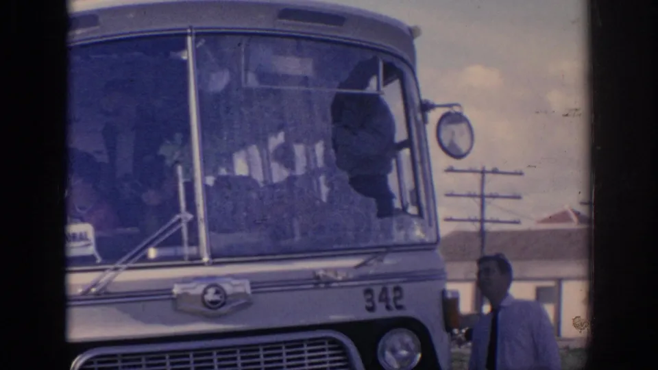 1966 Spain frame showing the damaged bus windshield and a nearby man in a light shirt and dark tie.