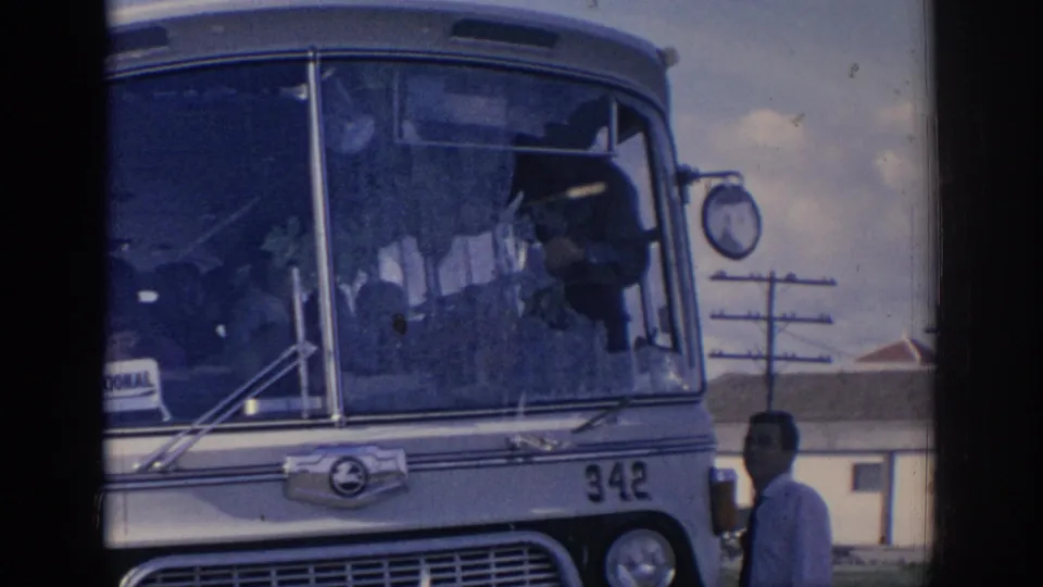 1966 Spain 8mm frame showing the damaged bus front, number 342, overhead wires, and a man partly visible at right.