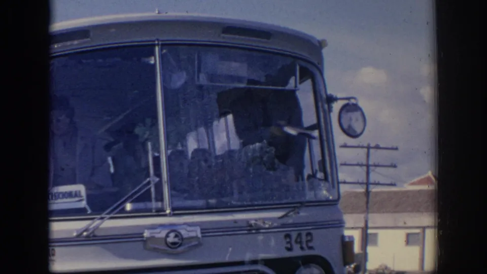 1966 Spain 8mm frame of the damaged public bus front, with shattered windshield glass, number 342, and street background details.