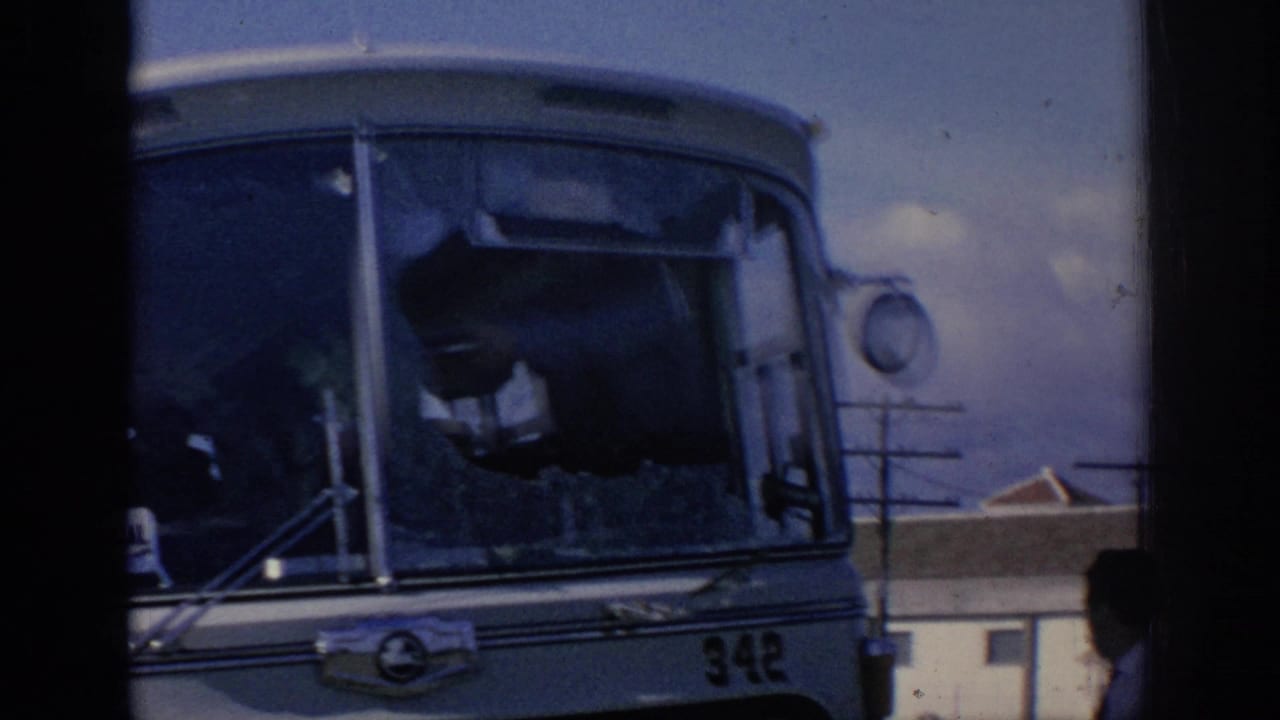 1966 Spain home-movie frame showing bus 342 with a broken windshield, a person inside, and a passerby at the edge.