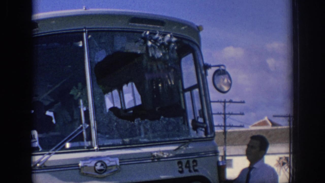 1966 Spain 8mm frame showing a passenger bus numbered 342 with shattered windshield glass and men inspecting the front area.