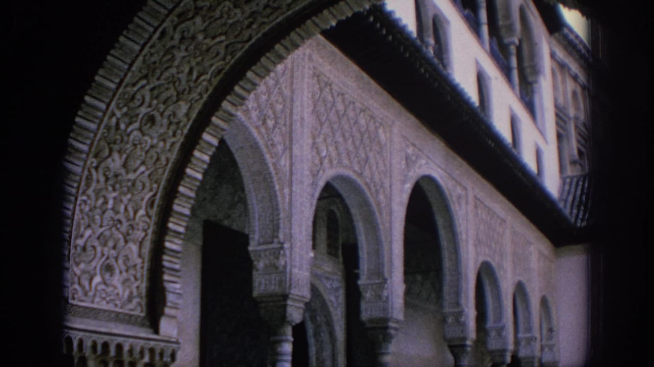 Ornate carved archway and repeating arcade columns in a shaded courtyard.