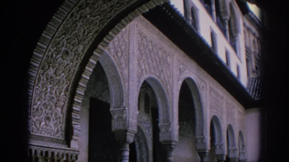 1966 Spain 8mm frame showing Moorish-style carved arch decoration and a row of shaded arcade columns.