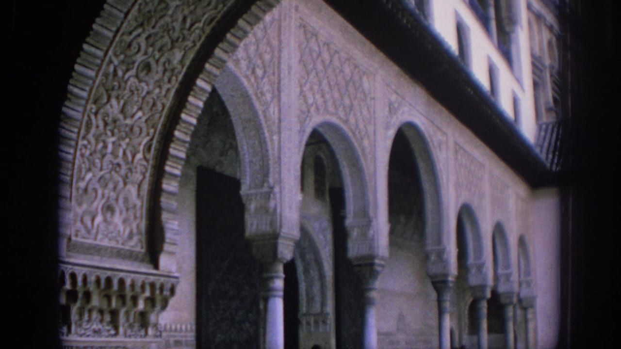 1966 Spain travel footage frame with ornate Moorish-style archwork and repeated courtyard arches.