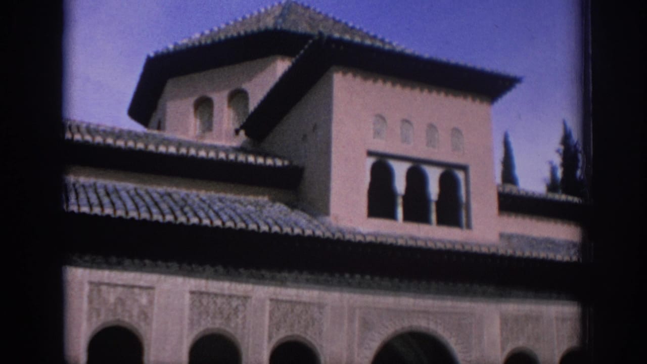 Upper facade with tiled roof, tower windows, arched openings, and dark film edges.