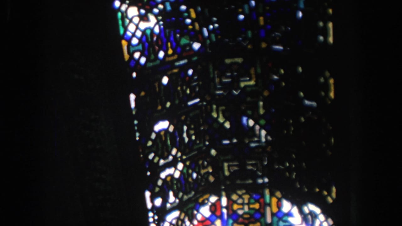 Close view of stained glass panels against a dark interior.