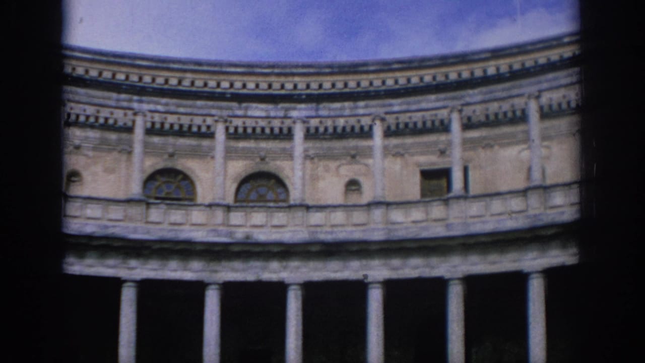 1966 Spain 8mm frame showing a curved classical stone building with columns and arched windows, partly obscured by dark film edges.