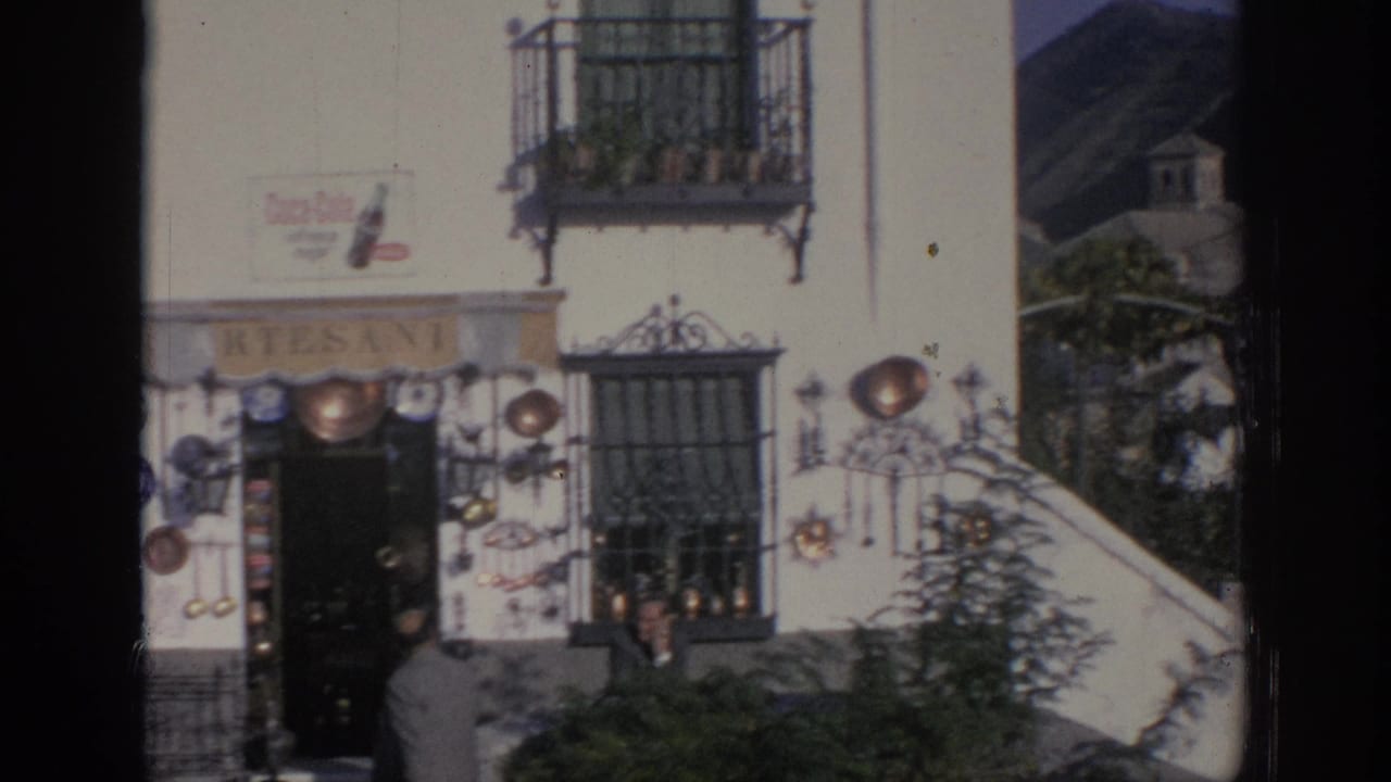 White artisan shop facade with cookware displays, Coca-Cola sign, balconies, and pedestrians.