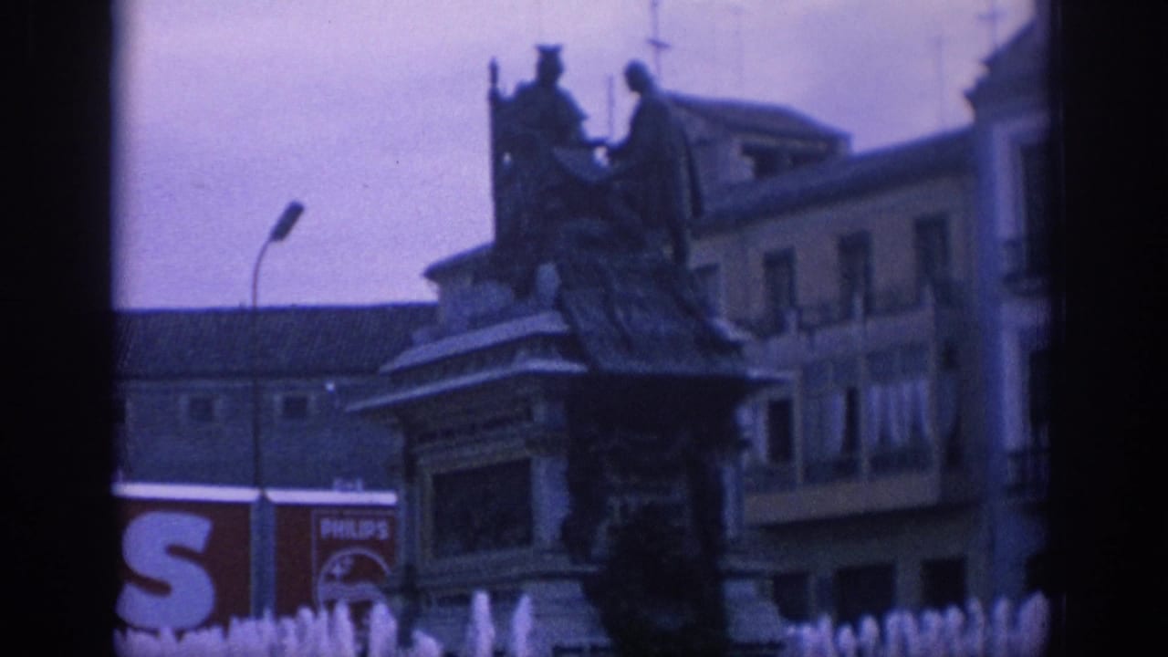 1966 Spain street-square view with a statue monument, surrounding buildings, a curved streetlamp, and a partial Philips advertisement in the background.