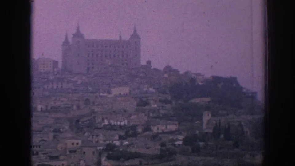 A similar 1966 Spain view holds on the hilltop structure identified in metadata as Toledo's Alcazar, with rooftops below and visible film grain.