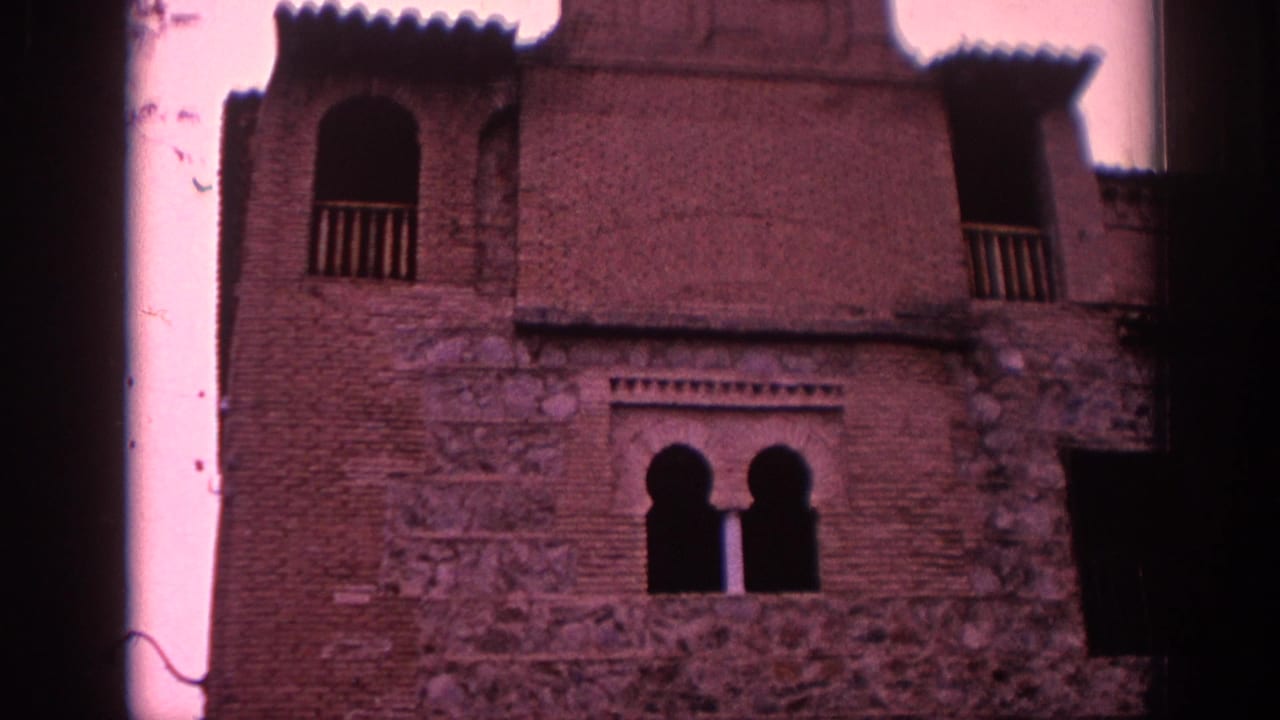1966 Spain frame of the Greco Museum facade, showing brick and stone surfaces, an arched balcony opening, and paired lower arches.