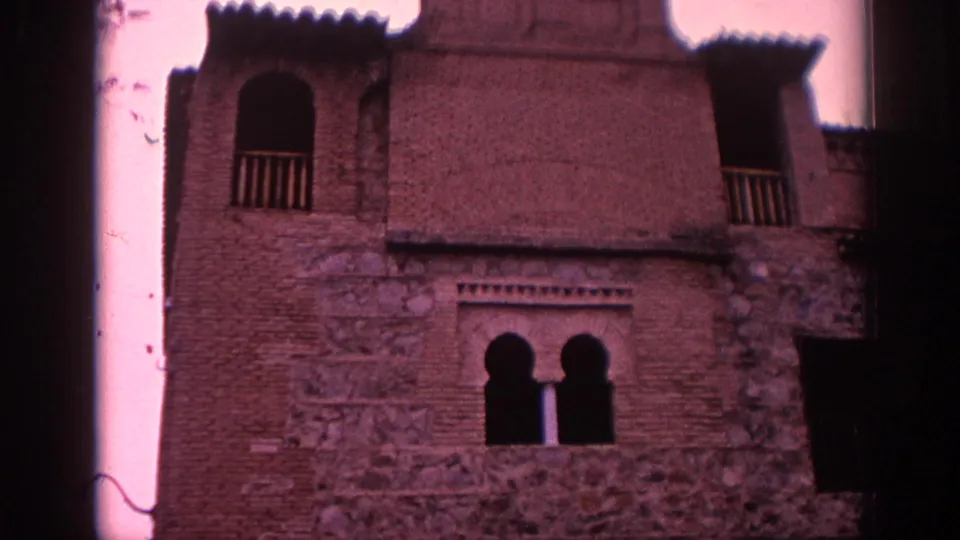 1966 Spain frame of the Greco Museum facade, showing brick and stone surfaces, an arched balcony opening, and paired lower arches.