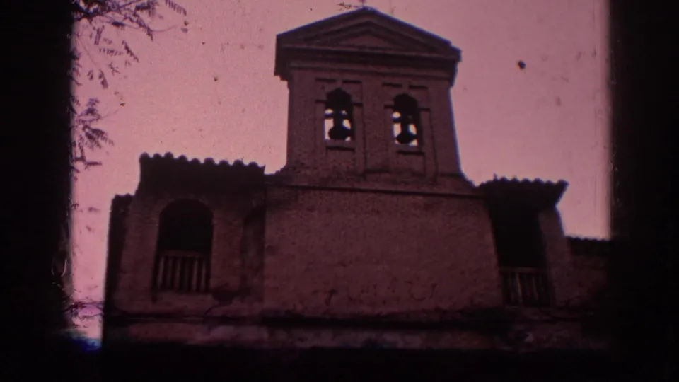 1966 Spain frame of the Greco Museum exterior, centered on the bell tower and upper facade with dark arched openings and aged color tint.