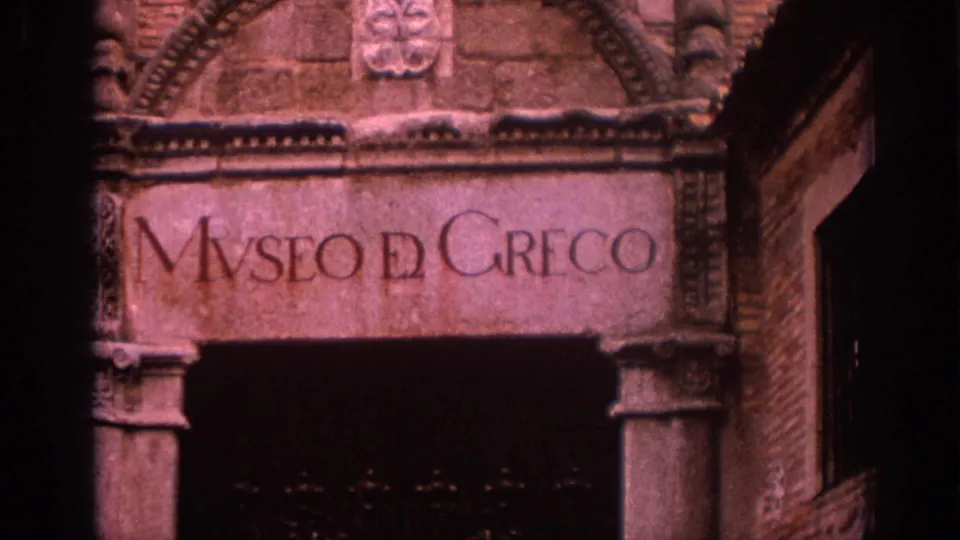 Visitor-shot 8mm view of the Museo del Greco inscription over a dark entrance, with carved masonry visible around it.