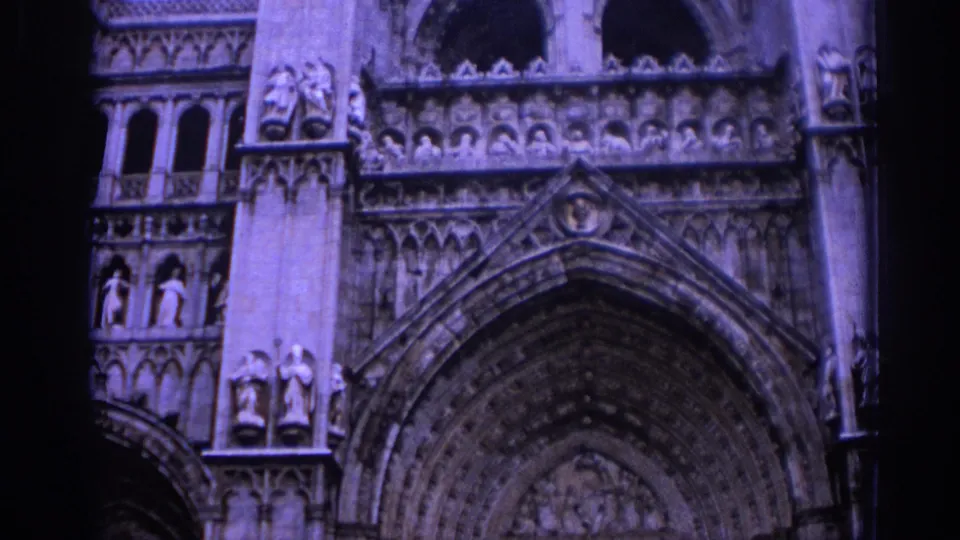 1966 Spain 8mm close view of the cathedral portal, showing layered Gothic arches, sculpted niches, and carved religious figures.