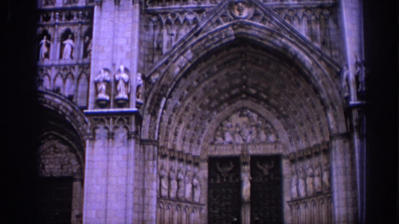 Gothic cathedral entrance with carved arches and dark doorway.