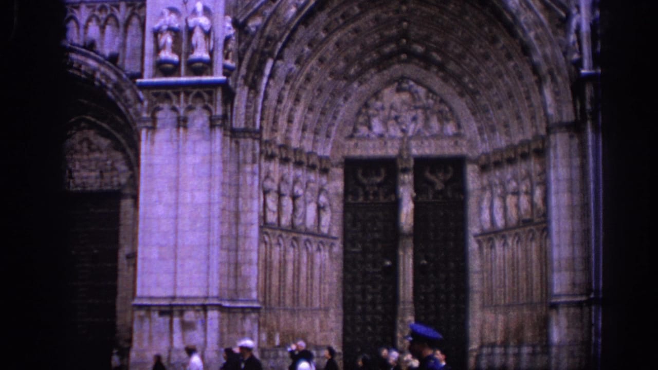 1966 Spain travel footage frames a Gothic cathedral portal with several distant people near the entrance.