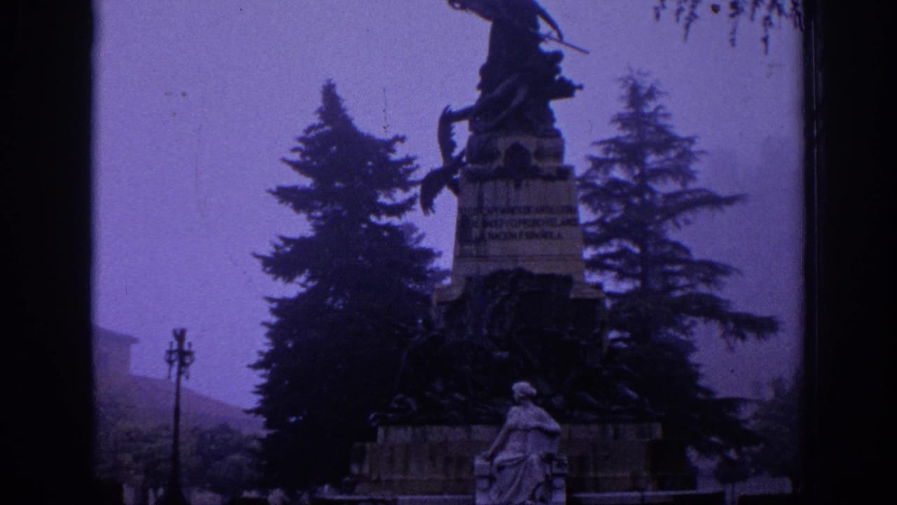 1966 Spain 8mm view of a public monument with an equestrian figure, stone base, trees, and a seated statue below.
