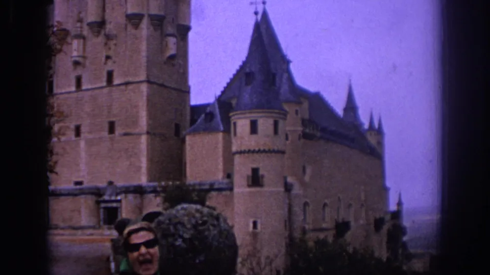 1966 Spain home-movie view of a turreted castle with visitors partly visible at the lower edge of the frame.