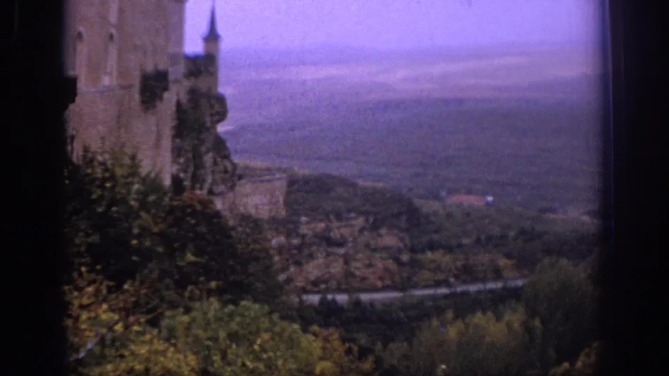 1966 Spain 8mm frame with a side view of the Alcazar of Segovia and valley below.