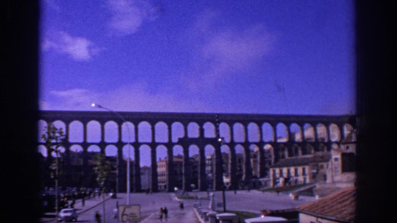 Aqueduct arches stretching across a city square under a blue sky.