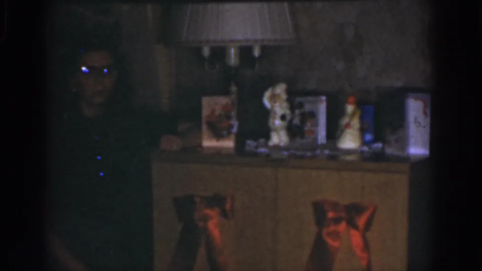A woman remains partly obscured at left in a 1968 Omaha Christmas interior, with a decorated cabinet and warm lamp light at center.