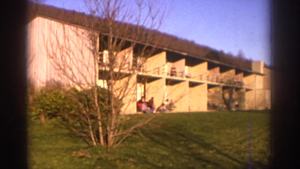 1971 Bedford, Virginia resort exterior showing a low modern building with balconies, lawn, bare trees, and people seated outside.