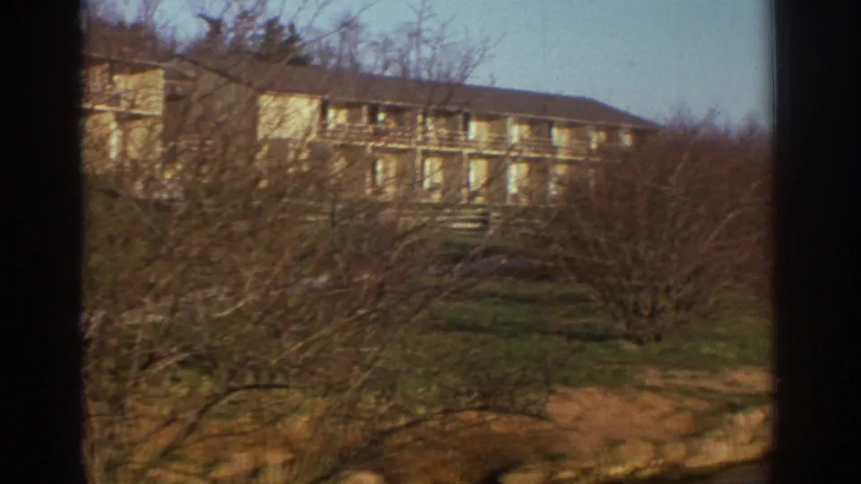The final frame shows the apartment complex across a grassy slope, partly veiled by bare branches in Bedford, Virginia.