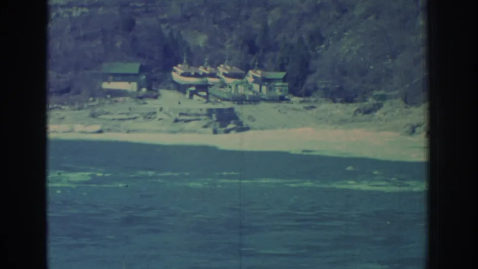 1971 Niagara Falls-area frame showing small boats near low shoreline structures below a wooded bank.
