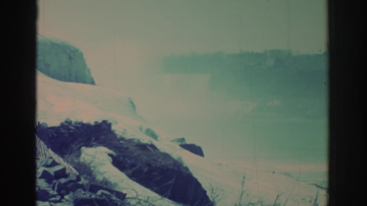 Misty snowy falls view with dark rocks and a vertical frame divider.