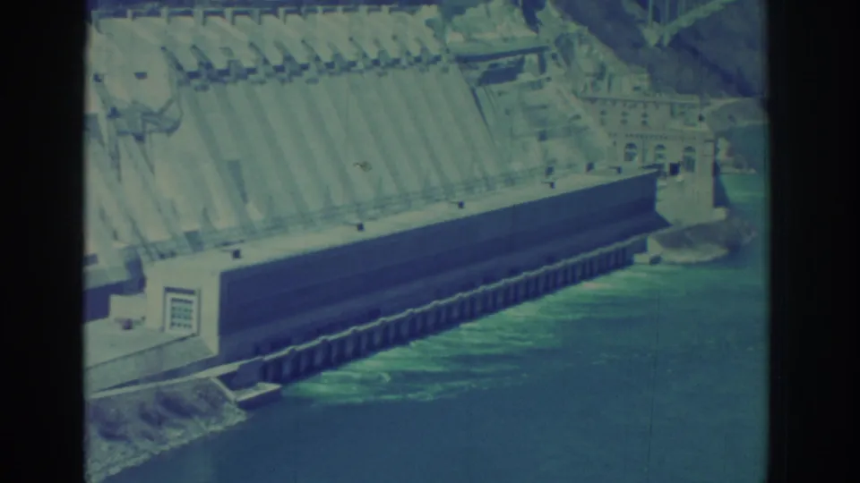 1971 8mm view of a Niagara Falls area dam face, river channel, and industrial shoreline details.