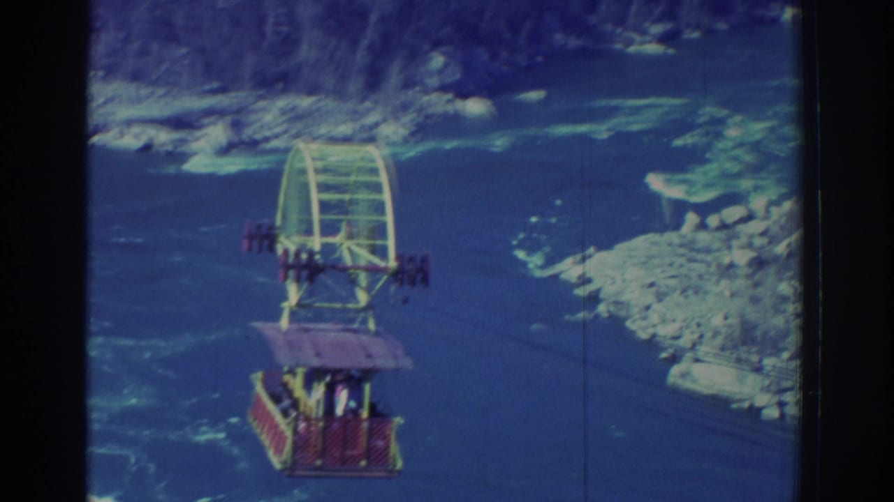 1971 8mm view of a colorful Niagara Falls sightseeing gondola suspended over the blue water of the gorge.