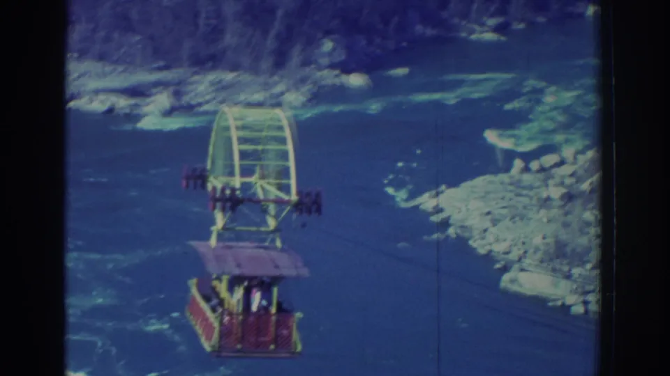 1971 8mm view of a colorful Niagara Falls sightseeing gondola suspended over the blue water of the gorge.