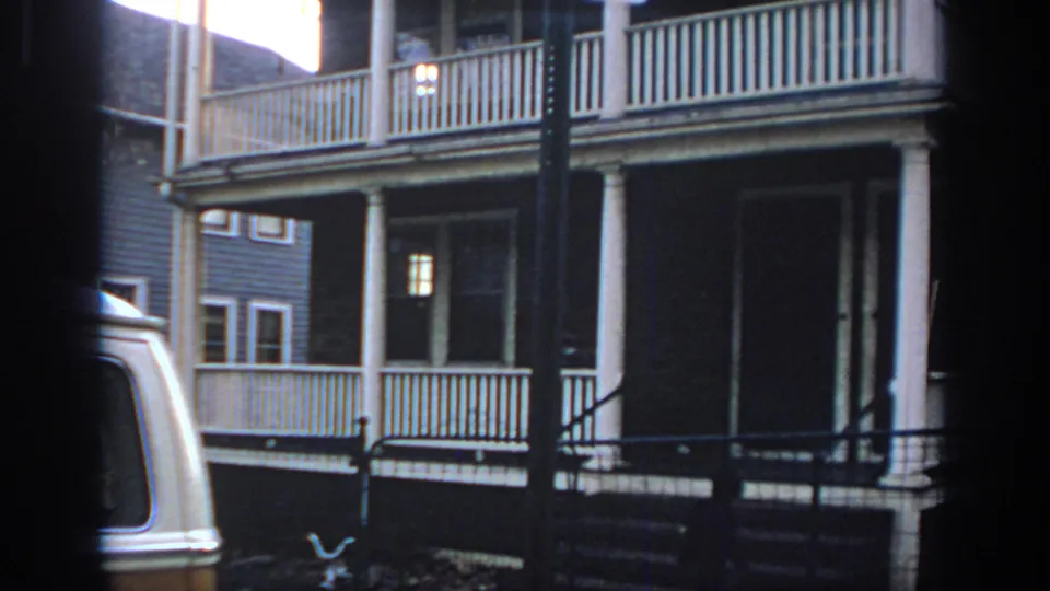 1972 Philadelphia residential frame showing porch columns, front steps, bicycle, metal gate, and a cropped van.
