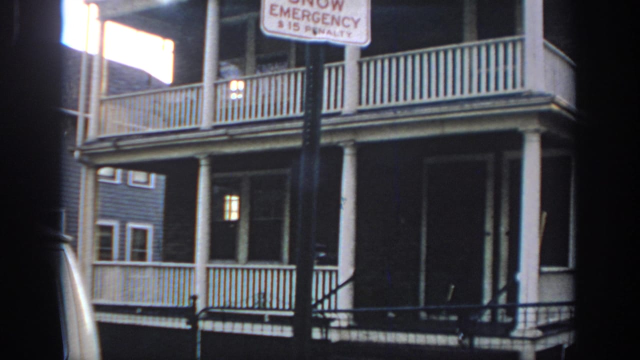 House porch with readable snow emergency parking sign near the frame top.