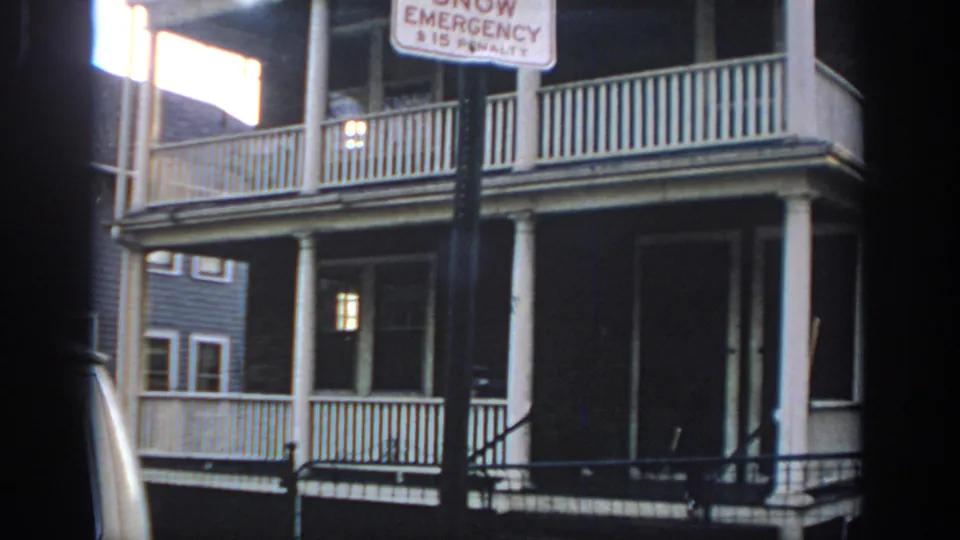 1972 Philadelphia street view with a snow emergency no-parking sign in front of a two-story house with white porch railings.