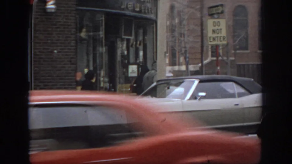 1972 Philadelphia street scene showing a storefront entrance, Do Not Enter sign, pedestrians, and blurred traffic.