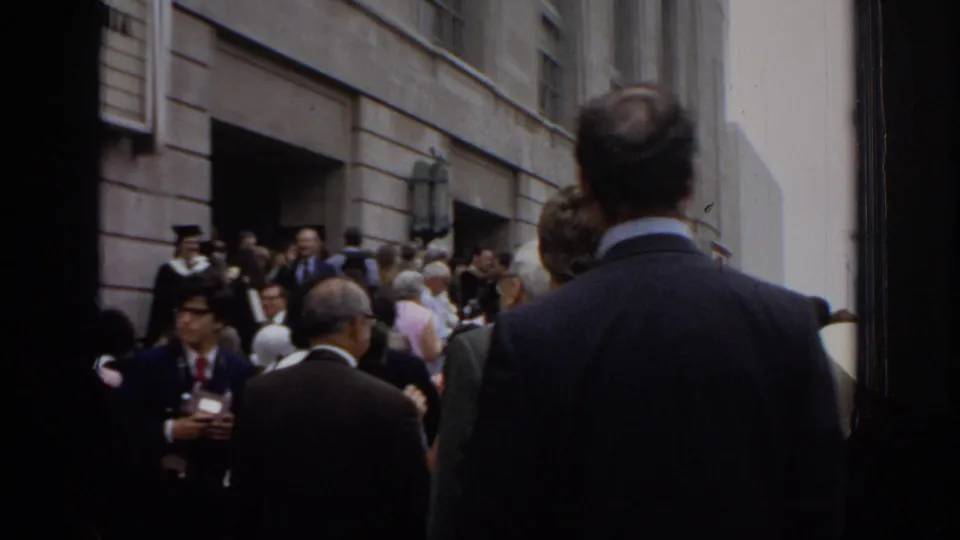 Graduates in caps and gowns and guests in formal clothing gather outside the Philadelphia Civic Center during the 1972 commencement event.