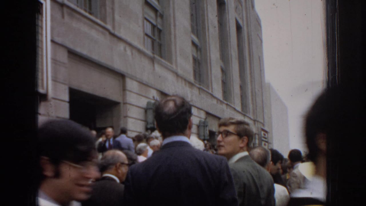1972 Philadelphia graduation attendees gather outside a stone civic-center facade with a partially visible commencement marquee.