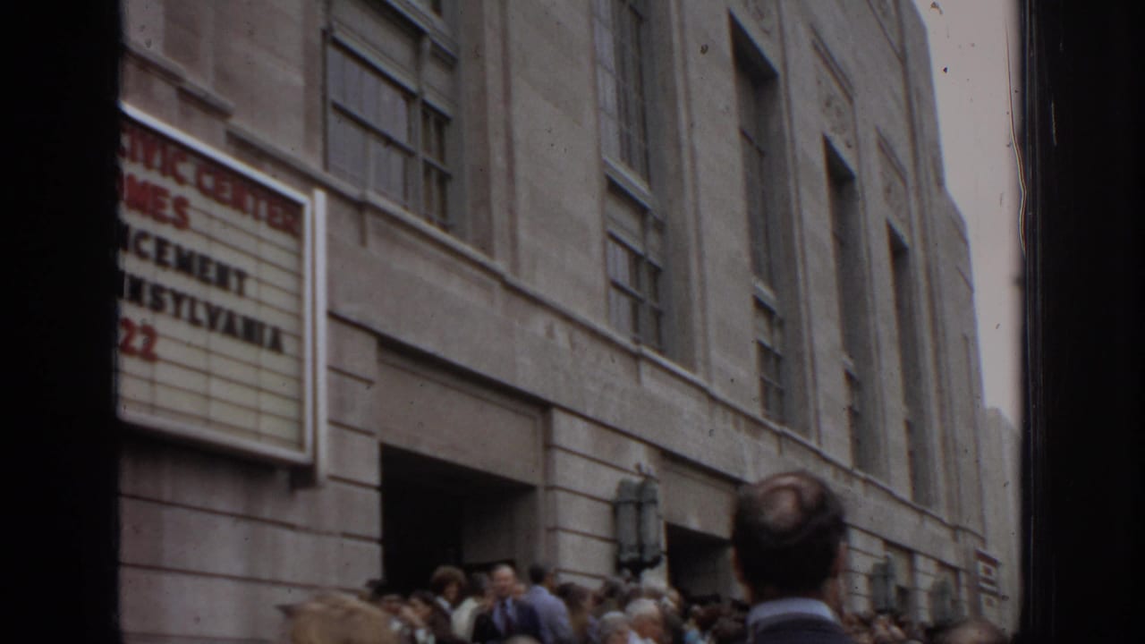 Civic-center marquee above a crowd outside a stone building.