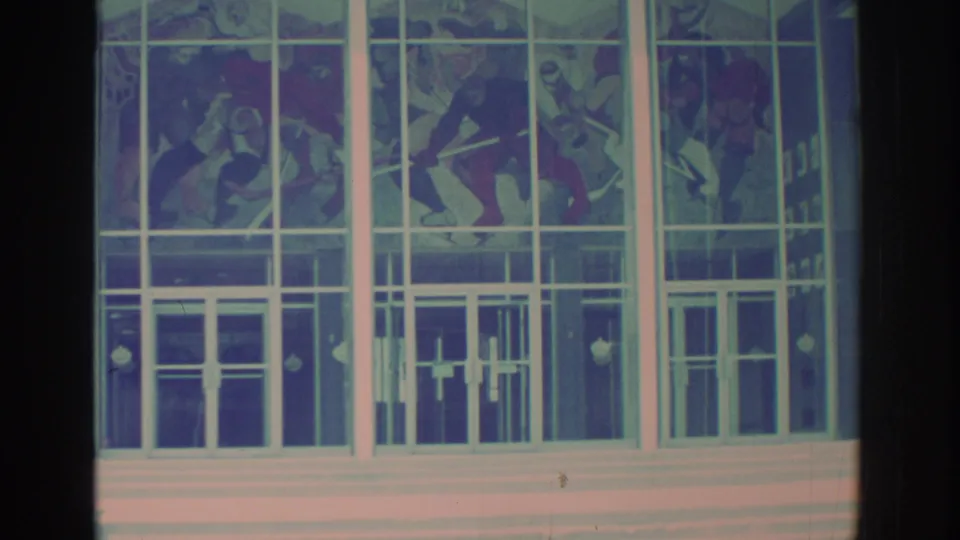 Toronto 8mm view of stained glass artwork set into a broad white-framed entrance facade, with film vignetting at the edges.