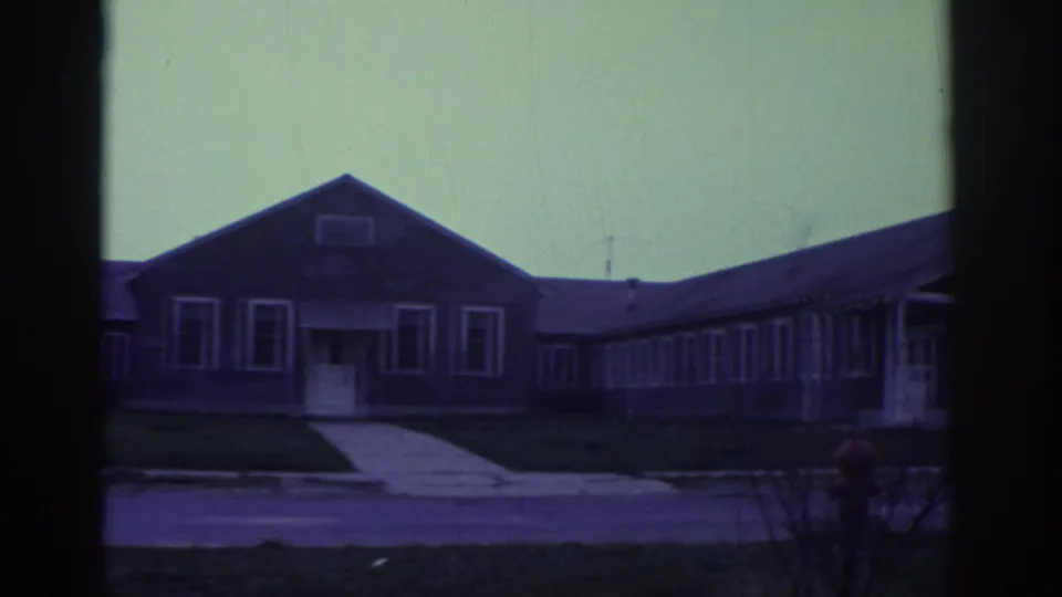The final frame shows a front-facing low building in Toronto with a central walkway, white-trimmed windows, lawn, and 8mm frame edges.